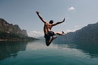 Man jumping with joy by a lake