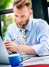 Bearded businessman taking notes