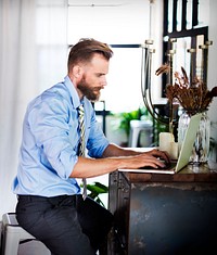 Bearded man working on a laptop