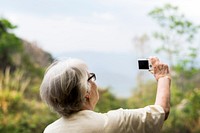 Senior woman taking a photo of the view