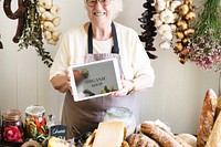 Senior woman selling organic gourmet produce at a deli