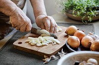 Cook slicing onions on a cutting board