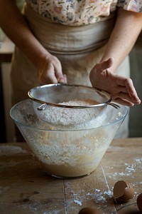 Woman sieving flour into a bowl