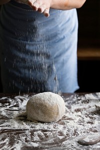 Woman preparing a dough on a wooden table