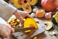 Woman slicing a pumpkin on a cutting board