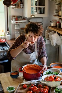 Woman tasting a tomato soup