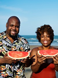 Couple eating watermelon on the beach