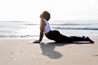 African American woman practicing yoga at the beach