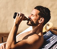 Man drinking a beer by the pool