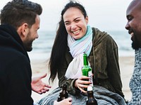 Friends drinking beer on the beach