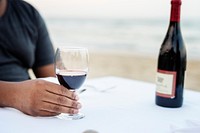 Man having a glass of wine by the sea