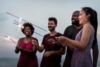 Friends celebrating with sparklers at the beach