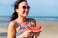 Young woman holding watermelon at the beach