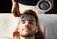 Man getting a mud mask at a spa