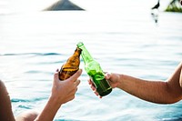 Young couple having a beer by the pool