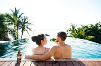 Young couple having a beer by the pool