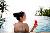 Woman enjoying a watermelon drink in the pool