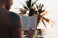 Man reading a book in the swimming pool