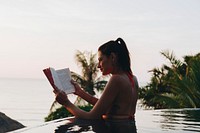 Woman reading a book in the swimming pool