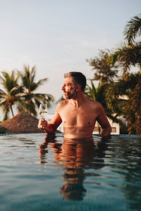 Man drinking wine in a swimming pool