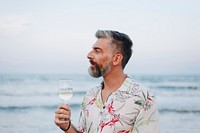 Man drinking a glass of wine by the beach