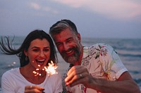 Couple celebrating with sparklers at the beach