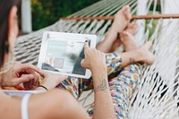 Couple using a tablet in a hammock