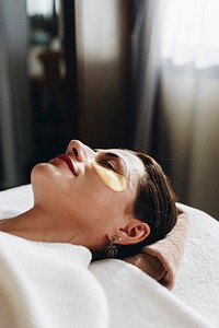 Woman relaxing with a golden eye mask treatment