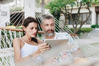 Couple using a tablet in a hammock
