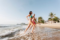 Cheerful couple running at the beach