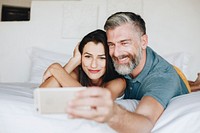 Honeymooners taking a selfie in bed