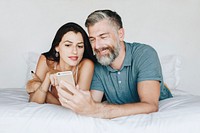 Couple using a smartphone in bed