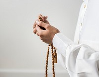 Muslim man using misbaha to keep track of counting in tasbih