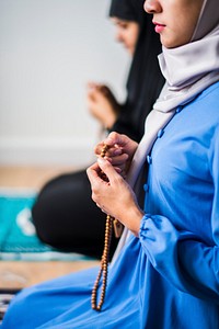 Muslim women using misbaha to keep track of counting in tasbih