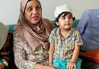 Muslim boy sitting with his grandmother