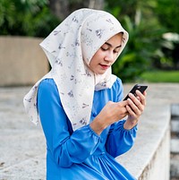 Muslim girl using a smartphone in the park