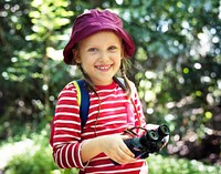 Little girl using binoculars in the forest