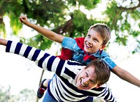 Superhero boy flying on the back of his dad