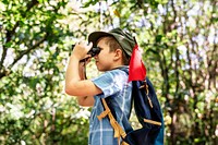Boy using binoculars in the forest