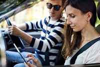 Woman using a digital tablet in the car