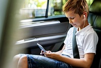 Boy playing on a smartphone in the car