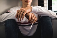 Young teen holding a stick of cigarette