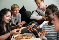 Friends hanging out in the living room eating pizza