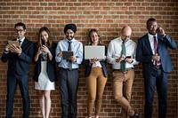 Business people standing in a row using electronic devices