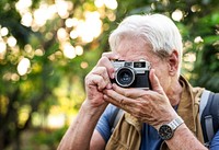 Senior trekker taking a photo with a film camera