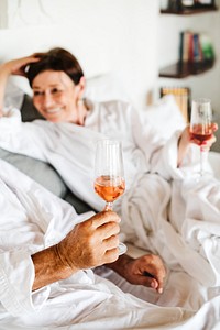 Couple drinking prosecco in bed