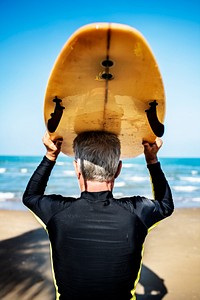 A senior man with a surfboard