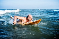 A senior man on a surfboard<br />