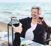 Mature friends drinking wine at the beach