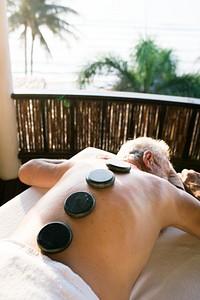 Mature man getting hot stone massage